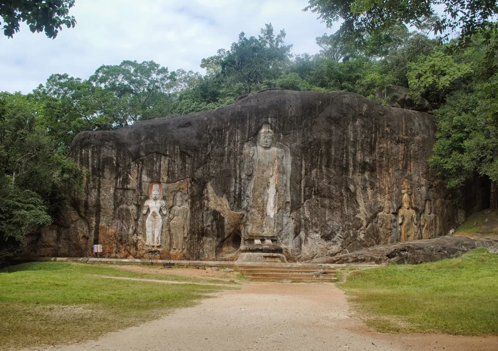 Colossal Buddha figures carved into the rock face at Buduruwagala, Sri Lanka